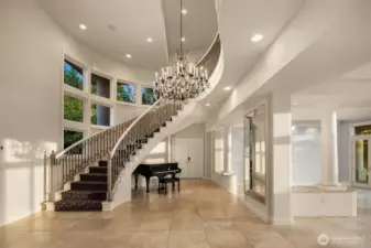 Grand spiral staircase & Juliet balcony at the entry. Gorgeous Torreon stone travertine floors flow effortlessly through the main level. Versailles reproduction w/pendalogue scalloped crystal chandelier.