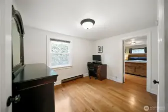 Second bedroom showing entry to the primary bedroom.