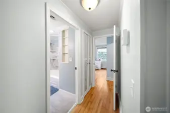 Another view of the hallway showing the full bathroom to the left and the entry leading to the third bedroom.