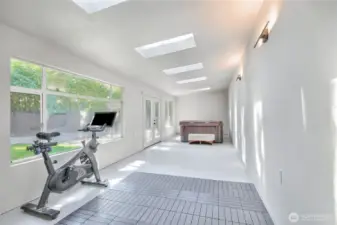 Solarium with tons of natural lighting, sky lights and hot tub open up to the backyard.