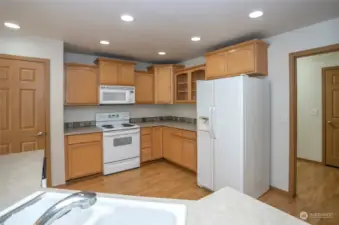 The kitchen boasts plenty of cabinets, and the door to the right leads to the utility room with access to the garage.
