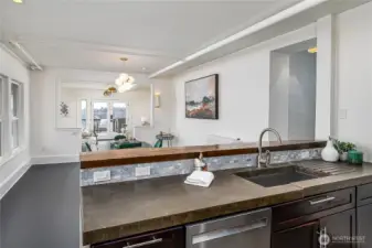 Kitchen features stainless steel appliances and custom concrete countertops.