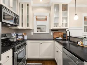 The charming kitchen has a gas cooktop and honed granite counters.