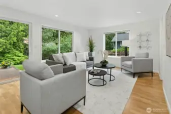 Cozy family room with lots of widows to enjoy the outdoor views as well as allowing for lots of natural light to enter this space and with more beautiful hardwood flooring.