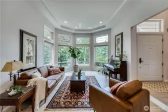 Sun drenched formal living room with coved ceiling, crown molding and hardwood floors.