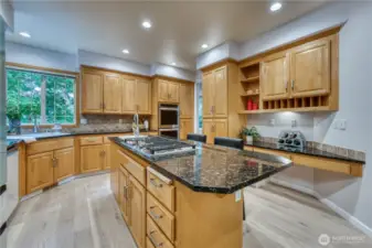 Kitchen offering a double oven, pantry cabinets, deck area and decorative shelving.