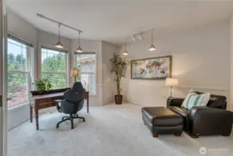 Sun drenched office off the entry with chair rail and optimal lighting.