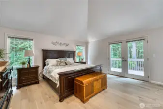 Another view of primary bedroom with french doors leading to private deck.