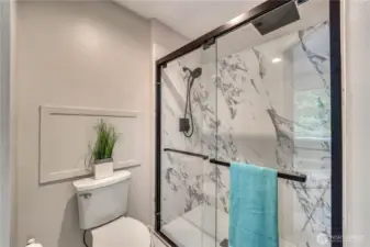Primary bath with newly done shower area. Beautiful marble style tile with black finishes.