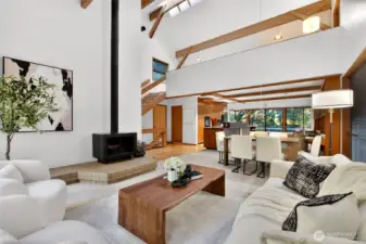 Exposed beams and floating stairs to loft surround living space with original wood burning stove