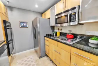 The kitchen also has a brand new refrigerator, recently replaced microwave, stove top range, and cool frosted glass cabinets.