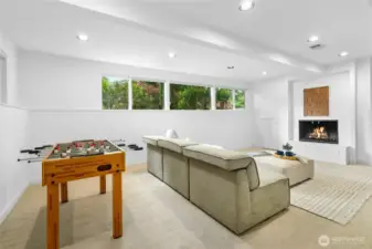 Large rec room with fireplace and space to play, relax, and enjoy movie nights.