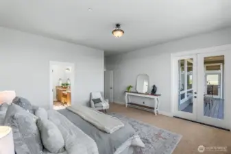 This view offers a peek into the luxurious spa-like bathroom to the left and the deck on the right.