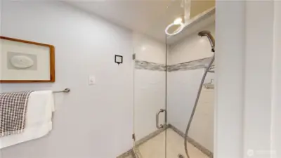 Designer tile and frameless glass door in this primary suite shower