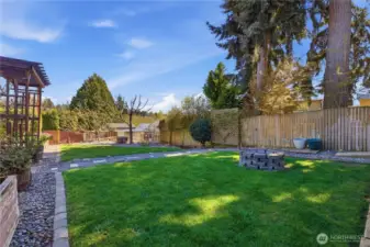 Park-like, fully fenced yard with chicken coup, greenhouse and RV parking with hook-up