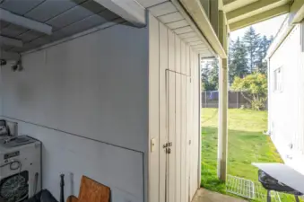 A convenient storage shed is situated at the end of the covered carport, with the backyard extending just beyond.