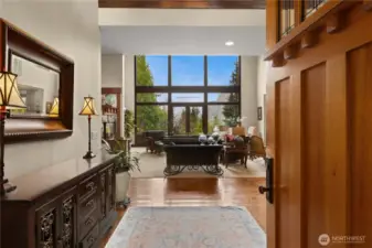 Open the front door to a double height foyer and living room with floor to ceiling windows framing a perfect view of Mt Si.