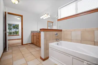 Looking back toward the primary bedroom from the tiled bath.