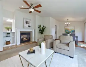 Another view of living room with showing shared fireplace with family room beyond.   Ornate mantle, tile hearth, bookcased, and opening which shares light from skylight in family room