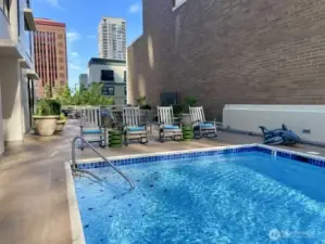 Outdoor heated pool on 4th floor with new deck chairs.