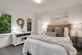 Main floor guest bedroom...There are five bedrooms, a bonus room, and three and a half baths, this home offers versatility for households of all sizes. The primary suite is a true retreat, featuring a luxurious en-suite bathroom, walk-in closet, and a private balcony with glimpses of Lake Washington and the Cascade Mountains. Two updated bathrooms and generous bedrooms ensure comfort for everyone