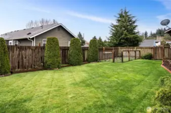 View of the back/side yard showing the fenced in garden area