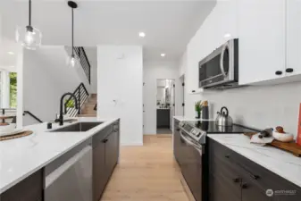 Sleek modern kitchen with stainless steel appliances, custom cabinetry, and stylish pendant lighting.