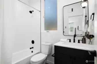 Modern bathroom design with black fixtures, vanity, and a clean, bright aesthetic.