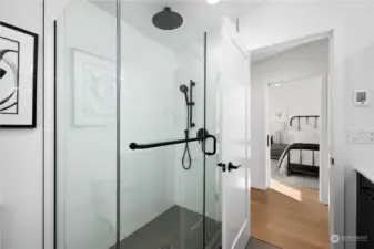 Frameless glass shower with modern black fixtures, offering a luxurious bathing experience.