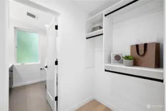 Custom walk-in closet with plenty of storage space, conveniently located next to the bathroom.