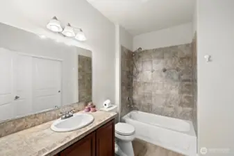Primary bathroom also with new LVP flooring and tile counters and full tub surround.