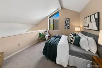 Primary bedroom upstairs. This has an attached bath and HUGE walk-in closet.  *Photo is from when the condo was staged.
