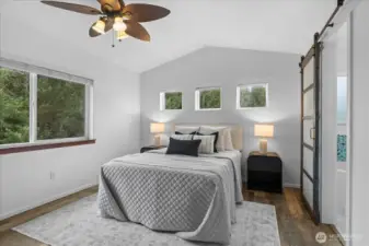 Primary suite with vaulted ceilings, ceiling fan & barn door to ensuite.