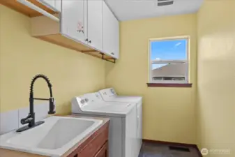 Upstairs laundry with cabinets and sink!