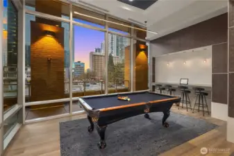 Billiards table with nearby bar seating.