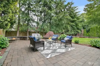 Large seren leveled backyard with planters and fire pit is partially fenced