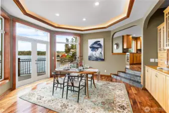 Dining room with built in China cabinet coved ceiling and double doors to the huge front deck.