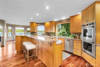 Double ovens, granite counters with island and tons of cabinets. Looking out at the water.