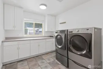 Spacious utility room with tile floors, ample storage and counter space. Conveniently located off oversized 3-car garage too!
