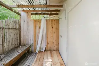 Adding to the studio’s rustic-luxe appeal, a private outdoor shower is tucked behind the building—surrounded by a fence and a couple of swaying bamboo plants. It’s the perfect spot to rinse off under the open sky, blending a sense of adventure with everyday comfort. A little touch of resort-style fun, right in your own backyard!
