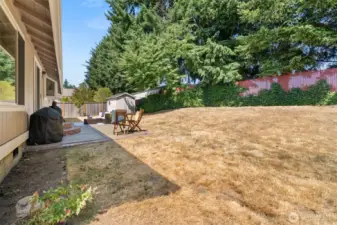Fully fenced backyard with mature trees for privacy.