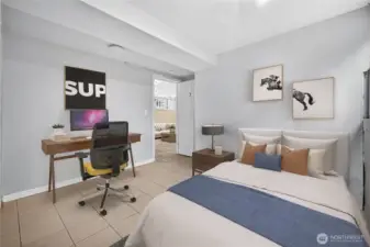 Basement bedroom with ample natural light, closet space, and room for a bed, storage, and study area. (Virtually Staged.)