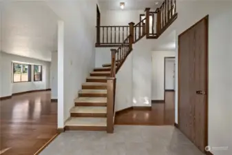 Welcoming foyer with vaulted ceilings, tiled floors and a grand stair case.