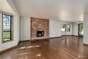 Beautiful brick fireplace in the living room. Notice the multiple elegant bay windows throughout the home.