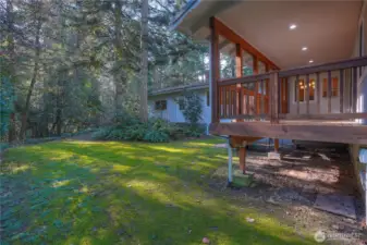 View of covered back deck and established grounds.