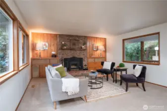 Enjoy relaxing in the formal living room complete with a cozy wood burning brick fireplace flanked by original  built-in cabinets with space for your entertainment system.