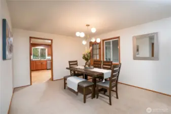 Formal dining room with door on the right that leads to the back covered deck and kitchen is beyond.