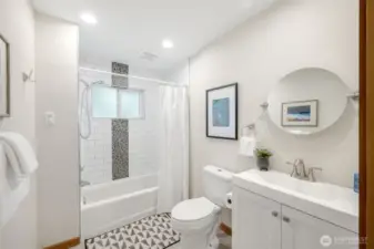 Main floor full bathroom with tub and room for storage.