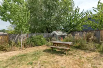 Spacious yard with nice deck, mature landscaping, garden area and greenhouse.