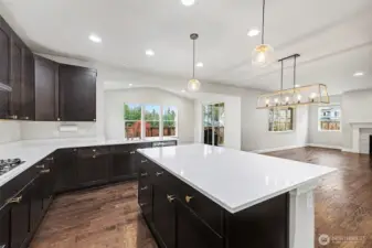 Perks to this great kitchen include the oversized island with seating, quartz countertops, double oven, and extra-large stainless steel refrigerator.